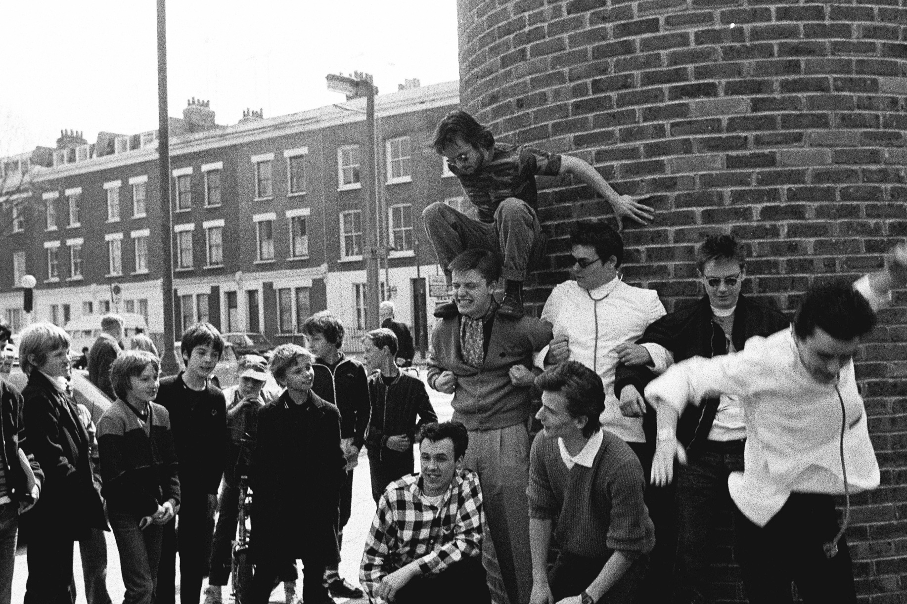 “This is Madness filming the video for House of Fun. It was my 20th birthday and we were filming all over London. This was Kilburn where we had just been filming in the off-licence and the group decided to do their human pyramid for a group of local kids that day. I got to star in a Madness video - I play the “gorgon who’s got her gossip”. Clare Muller